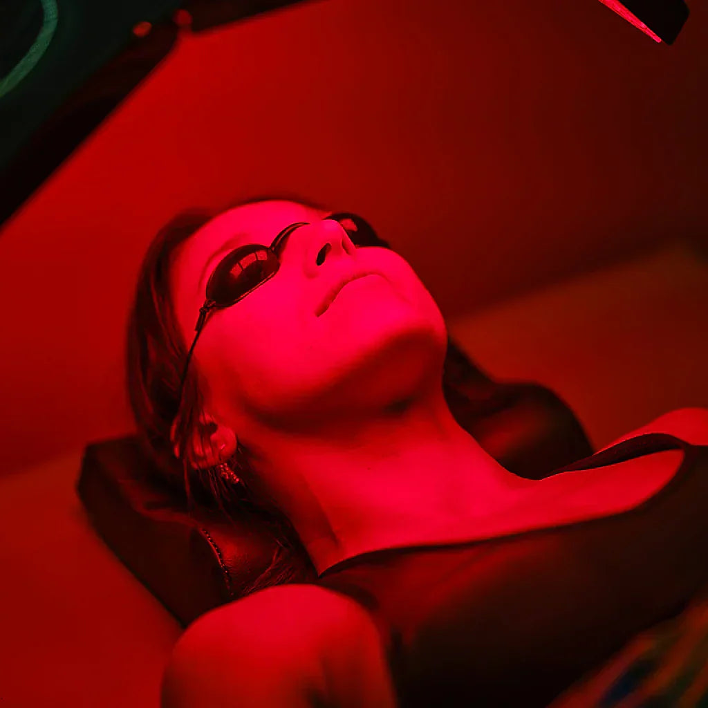 Person wearing silicone eye shields during red light therapy mask session